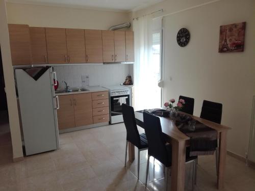 a kitchen with a table and chairs and a refrigerator at Jordan's 4th Appartment at Nea Michaniona in Néa Michanióna