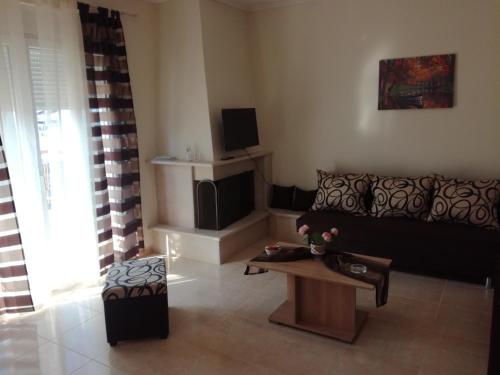 a living room with a couch and a tv at Jordan's 4th Appartment at Nea Michaniona in Néa Michanióna