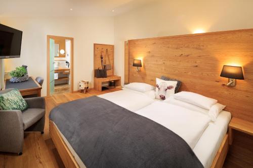 a bedroom with a large bed and a couch at Hotel Natur-Landhaus Krone in Maierhöfen
