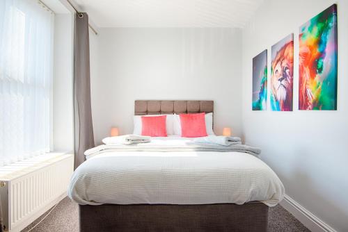 a bedroom with a large bed with red pillows at 3 Bedrooms, Parking & Courtyard in Swansea