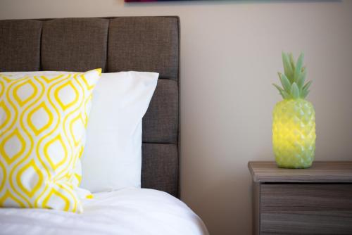 a pineapple sitting on top of a bed with a pillow at 3 Bedrooms, Parking & Courtyard in Swansea