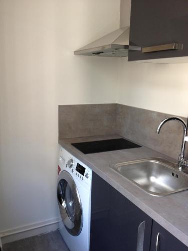 eine Küche mit einer Waschmaschine und einem Waschbecken in der Unterkunft Appartement Cherche-Midi in Paris