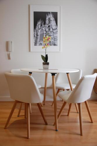 d'une table à manger avec des chaises blanches et une plante. dans l'établissement River View, à York