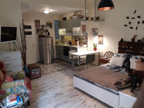 Una sala de estar con una cama y una cocina. en Studio Karma, en Budapest