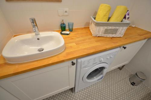 a bathroom with a sink and a washing machine at Ferienwohnung PRESIDENTE - Pool - Glasfaserinternet - Costa Calma in Costa Calma