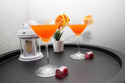 two cocktails sitting on a black table with ice cubes at Ora Luxury Rooms in Dubrovnik