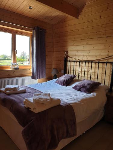 a bedroom with a large bed in a log cabin at Ruth's Retreat Shropshire Countryside Lodge with private hot tub & great views in Shrewsbury