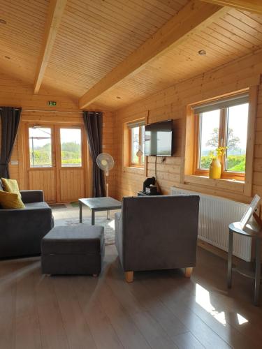 a living room with couches and a flat screen tv at Ruth's Retreat Shropshire Countryside Lodge with private hot tub & great views in Shrewsbury