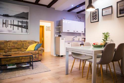 ein Wohnzimmer mit einem Tisch und einer Küche in der Unterkunft Luxurious apartment with private garden in Split