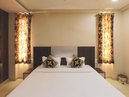 - une chambre avec un grand lit blanc et des rideaux dans l'établissement Travelling Troopers Homestay, à Varanasi