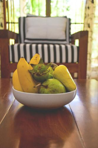 a bowl of bananas and pears on a wooden table at CASA VACANSA HOME STAY in Hungama