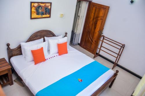 a bedroom with a bed with orange and blue pillows at CASA VACANSA HOME STAY in Hungama