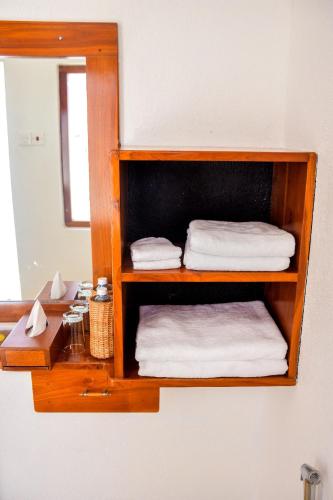 a wooden shelf with towels and a mirror in a bathroom at CASA VACANSA HOME STAY in Hungama