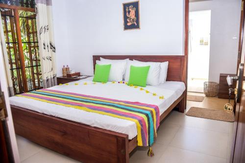 a bedroom with a large bed with green pillows at CASA VACANSA HOME STAY in Hungama