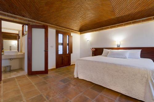 a bedroom with a large bed and a bathroom at Hotel Casa Real Del Café in Coatepec