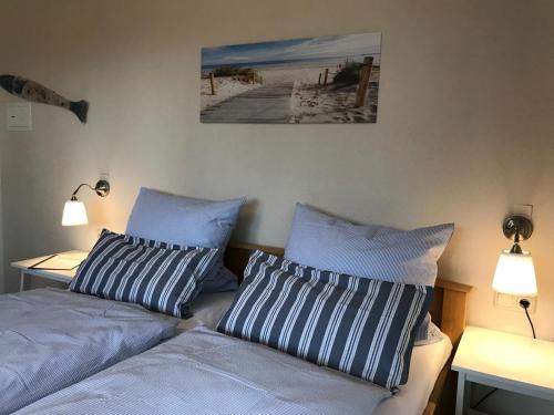 a bedroom with two beds with blue and white pillows at Hotel Gasthuus Spieskamer in Hasselberg