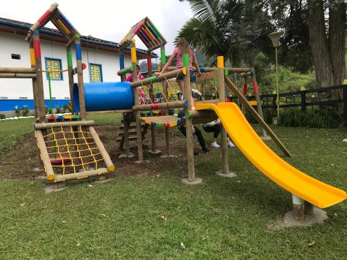 a playground with a slide in the grass at Hotel Bariloche in Santa Rosa de Cabal