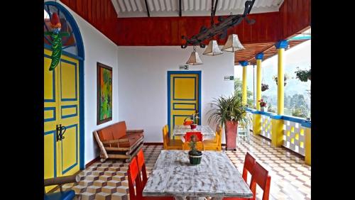 a living room with a table and chairs and a house at Hotel Bariloche in Santa Rosa de Cabal