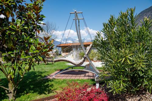a swing in the middle of a garden at Hotel Neuhausmühle in Vilpiano