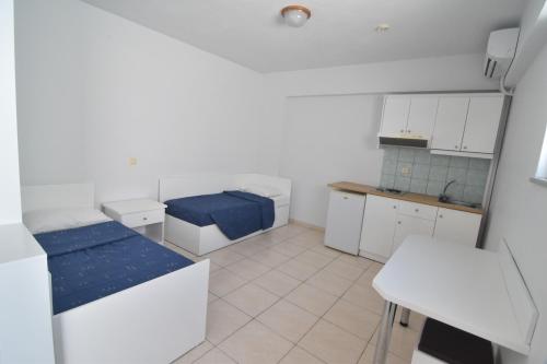 a small kitchen with two beds and a table at Evripides Village in Kardamaina