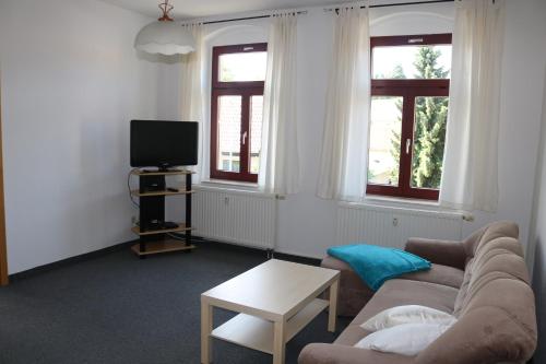 sala de estar con sofá y TV en Ferienwohnung Post, en Ottendorf-Okrilla