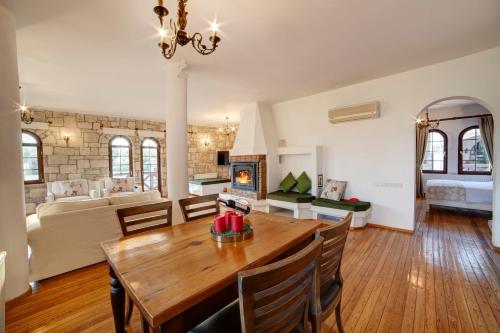 a dining room and living room with a wooden table at VINIFERA VINEYARDS HOTEL in Selcuk