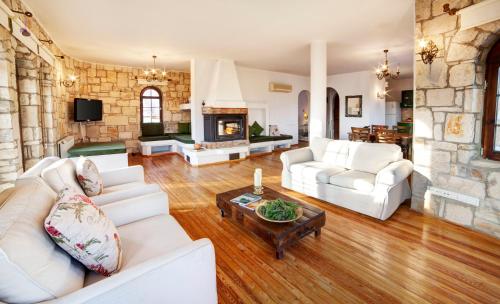 a living room with white furniture and a stone wall at VINIFERA VINEYARDS HOTEL in Selcuk