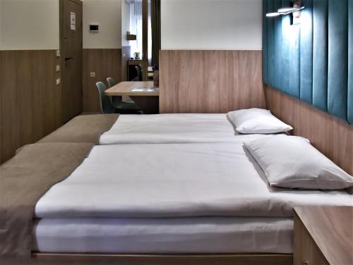 a large bed with white sheets and pillows at EXPO Hotel Comfort in Kyiv
