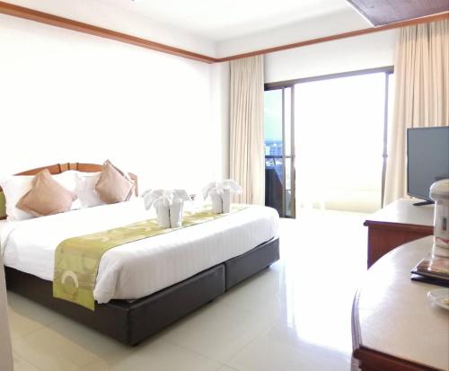 a bedroom with a bed and a large window at Green World Palace Hotel in Songkhla