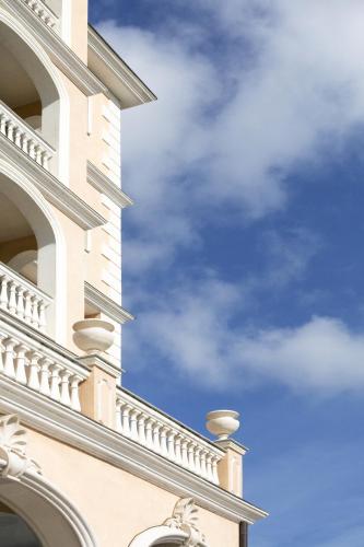 a white building with a blue sky in the background at Grand Hotel President in Olbia