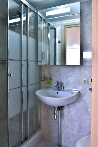 a bathroom with a sink and a shower and a mirror at EXPO Hotel Comfort in Kyiv