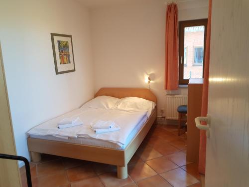 ein Schlafzimmer mit einem Bett mit zwei Handtüchern darauf in der Unterkunft Ferienwohnung Mönchgut 1 mit Wintergarten und Terrasse in Ostseebad Sellin