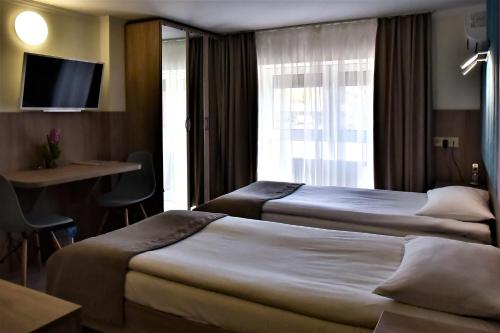 two beds in a hotel room with a window at EXPO Hotel Comfort in Kyiv
