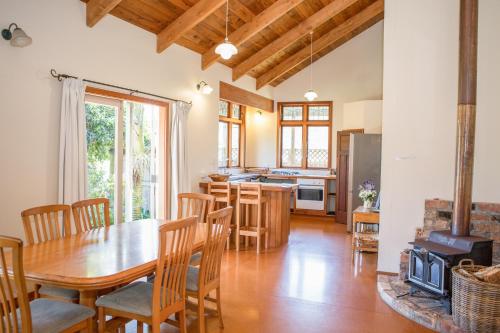 a kitchen and dining room with a wooden table and chairs at The Church Accommodation in Hahei