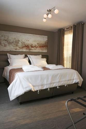 a bedroom with two beds with white sheets and a window at Luxury Apartments by Atelier VO2 max with Large Terrace and Parking 10 min from Beach in Knokke-Heist