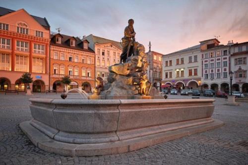 a fountain in the middle of a city with buildings at Apartmán Dračí údolí in Trutnov