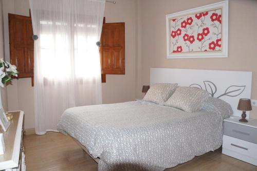 1 dormitorio con 1 cama y una pintura en la pared en Apartamento Salvador 37, en Almagro