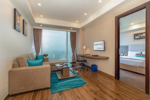 a living room with a couch and a bed at Golden Suites Gurgaon Inde Hotels in Gurgaon