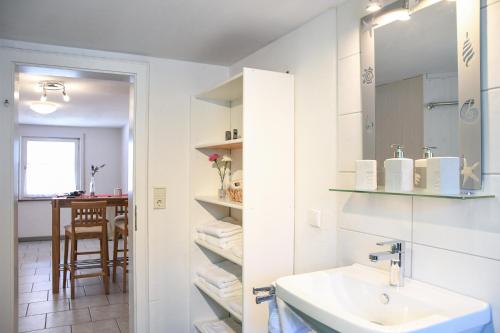 a white bathroom with a sink and a mirror at Ferienwohnungen zur Elz in Kappel-Grafenhausen