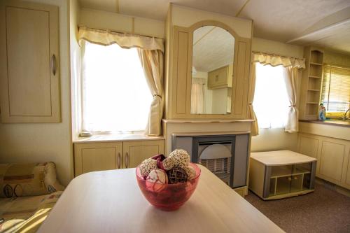 a room with a table with a bowl on a table with a fireplace at Mobile homes Marina Liptov in Bešeňová