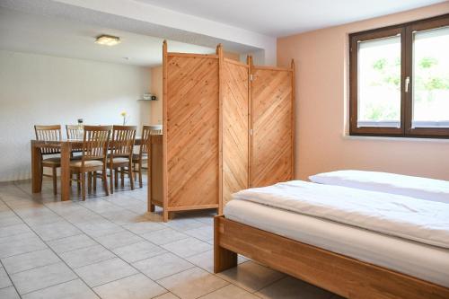 a bedroom with a bed and a dining room with a table at Ferienwohnungen zur Elz in Kappel-Grafenhausen