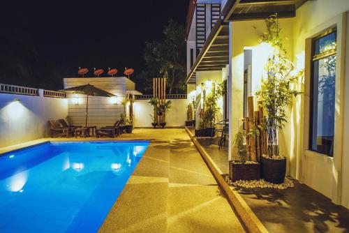 a swimming pool in front of a house at night at Quest Villa in Panglao