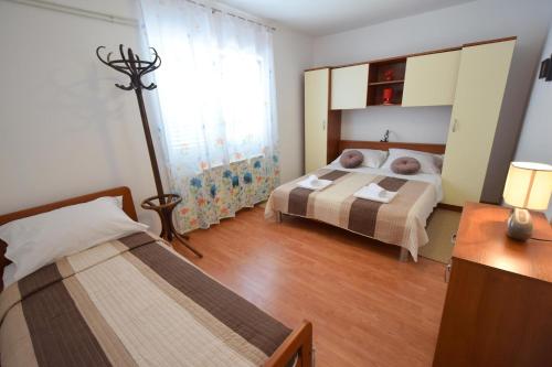 a bedroom with two beds and a mirror at Apartments Anka in Krk