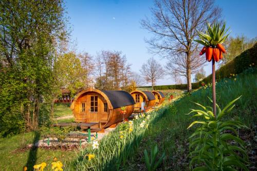 a row of yurt homes in a garden with flowers at Camping & Pension Au an der Donau in Au an der Donau