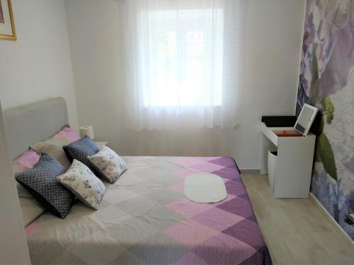 扎达尔Holiday Home Arbanase的卧室配有带枕头的床铺和窗户。