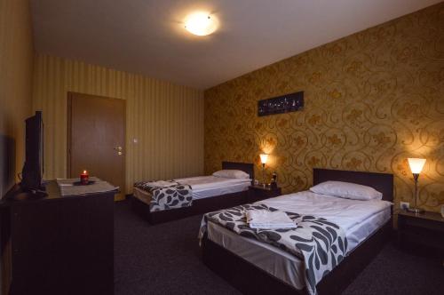 a hotel room with two beds and a television at Elite Spetema Hotel in Sofia