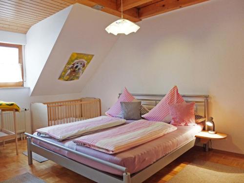 een slaapkamer met een bed met roze kussens erop bij Haus-Haller in Friedrichshafen
