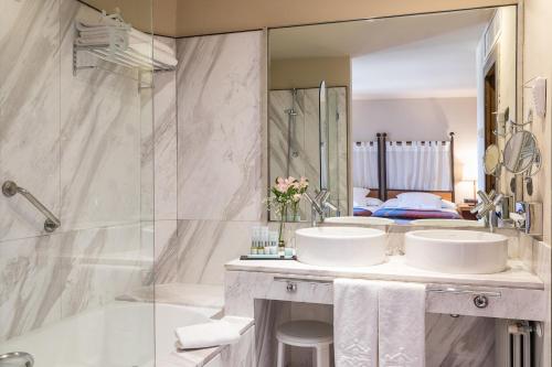 a bathroom with two sinks and a shower at Parador de Alarcón in Alarcón