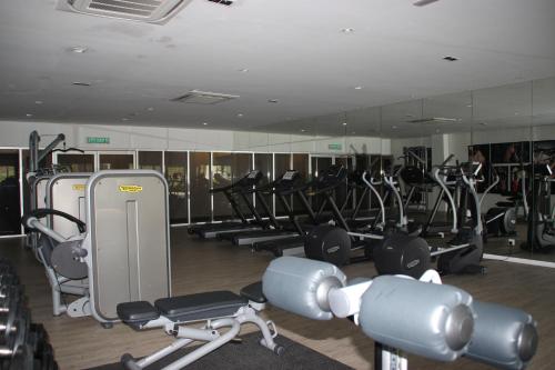a gym with rows of treadmills and exercise bikes at Meridin Medini Muslim Condo in Nusajaya