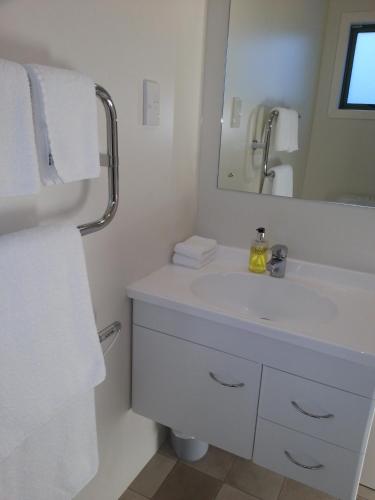 a bathroom with a white sink and a mirror at Martinborough TOP 10 Holiday Park in Martinborough 